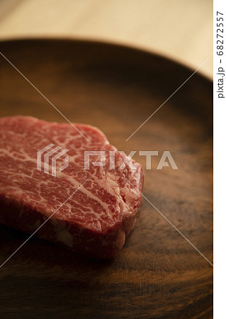 木の机の上のアカシアプレートに乗せた生の肉厚牛フィレステーキ 木の机の上のアカシアプレートに乗せた生の肉厚牛フィレステーキ 68272557