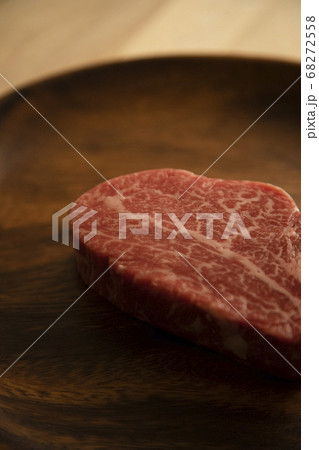 木の机の上のアカシアプレートに乗せた生の肉厚牛フィレステーキ 木の机の上のアカシアプレートに乗せた生の肉厚牛フィレステーキ 68272558