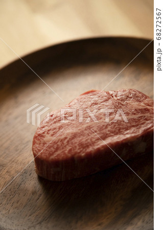 木の机の上のアカシアプレートに乗せた生の肉厚牛フィレステーキ 木の机の上のアカシアプレートに乗せた生の肉厚牛フィレステーキ 68272567