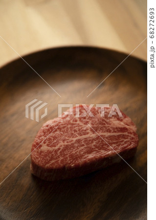 木の机の上のアカシアプレートに乗せた生の肉厚牛フィレステーキ 木の机の上のアカシアプレートに乗せた生の肉厚牛フィレステーキ 68272693