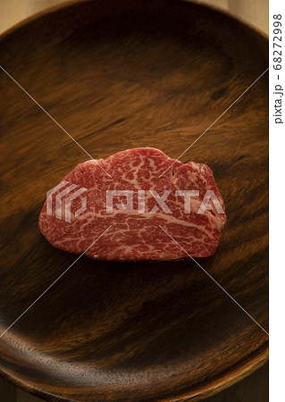 木の机の上のアカシアプレートに乗せた生の肉厚牛フィレステーキ 木の机の上のアカシアプレートに乗せた生の肉厚牛フィレステーキ 68272998