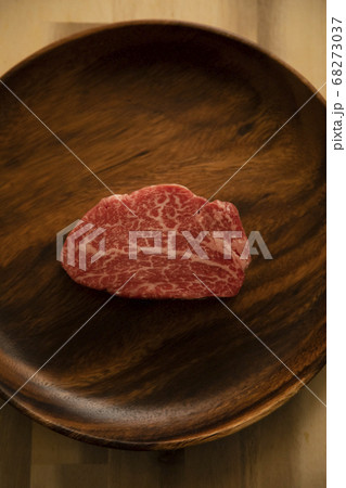 木の机の上のアカシアプレートに乗せた生の肉厚牛フィレステーキ 木の机の上のアカシアプレートに乗せた生の肉厚牛フィレステーキ 68273037