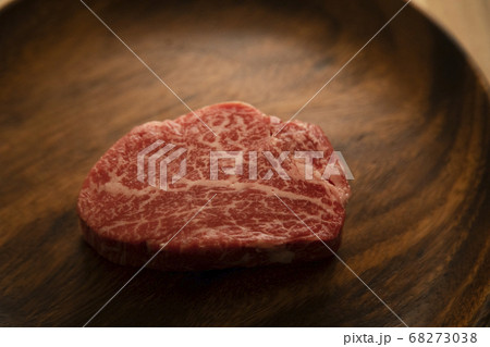 木の机の上のアカシアプレートに乗せた生の肉厚牛フィレステーキ 木の机の上のアカシアプレートに乗せた生の肉厚牛フィレステーキ 68273038