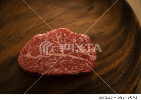 木の机の上のアカシアプレートに乗せた生の肉厚牛フィレステーキ 木の机の上のアカシアプレートに乗せた生の肉厚牛フィレステーキ 68273043