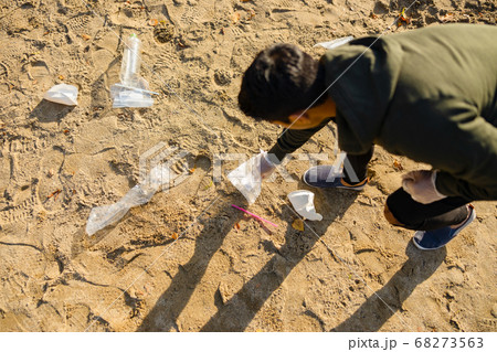 Top view of volunteer protecting environmental and picking up garbage at beach Top view of volunteer protecting environmental and picking up garbage at beach 68273563