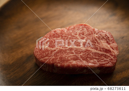 木の机の上のアカシアプレートにのせた生の肉厚牛フィレステーキ 木の机の上のアカシアプレートにのせた生の肉厚牛フィレステーキ 68273611