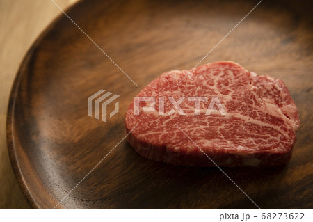 木の机の上のアカシアプレートにのせた生の肉厚牛フィレステーキ 木の机の上のアカシアプレートにのせた生の肉厚牛フィレステーキ 68273622