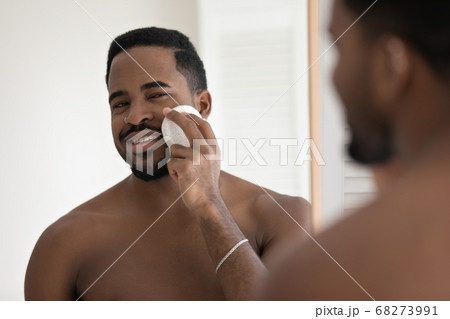 Head shot mirror reflection African American man using cleansing sponge Head shot mirror reflection African American man using cleansing sponge 68273991