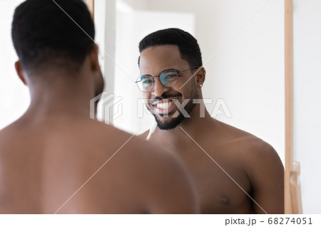Head shot mirror reflection smiling African American man brushing teeth 68274051