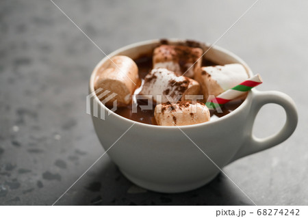 Cocoa drink with marshmallow and christmas drinking straw in white cup on terrazzo surface with copy space 68274242