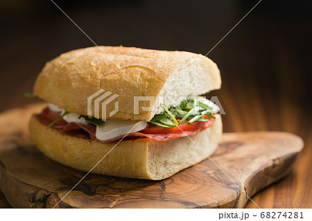 ciabatta sandwich with salami and mozzarella cheese on walnut table ciabatta sandwich with salami and mozzarella cheese on walnut table 68274281