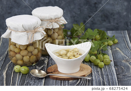 Pickled homemade gooseberries in a jar and in  68275424