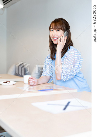 カフェでソーシャルディスタンスをとりながら電話をする若い女性1人 カフェでソーシャルディスタンスをとりながら電話をする若い女性1人 68280055