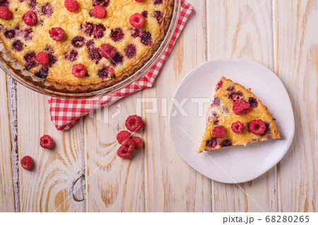 Sweet tasty pie with jellied and fresh raspberry fruits in baking dish and plate 68280265