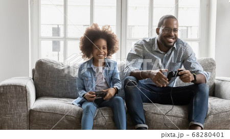 Happy ethnic dad and daughter play video games 68280401