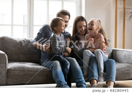 Joyful young parents having fun with little laughing children. 68280445