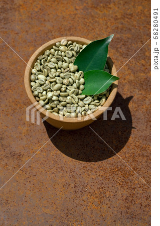 green coffee beans in wooden bowl 68280491