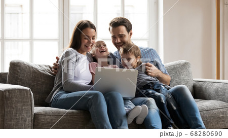 Happy bonding family enjoying watching funny comedian movie on laptop. Happy bonding family enjoying watching funny comedian movie on laptop. 68280690