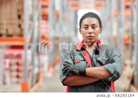 Young serious mixed-race female worker of warehouse crossing arms by chest Young serious mixed-race female worker of warehouse crossing arms by chest 68283164