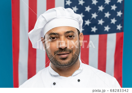 Young successful chef of restaurant in white uniform standing in front of camera Young successful chef of restaurant in white uniform standing in front of camera 68283342