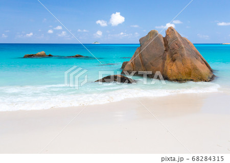 Beach with blue water and blue sky and some rocks Beach with blue water and blue sky and some rocks 68284315