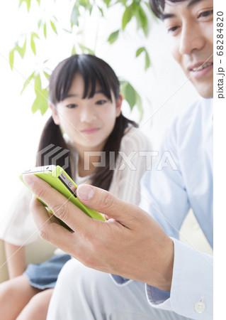 スマホを見る親子 68284820