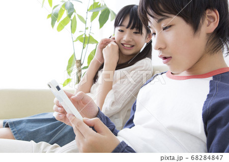 スマートフォンを見る兄妹 スマートフォンを見る兄妹 68284847