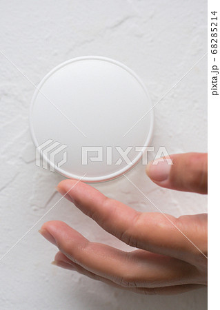 A woman's hand with a jar of face cream on a white 68285214