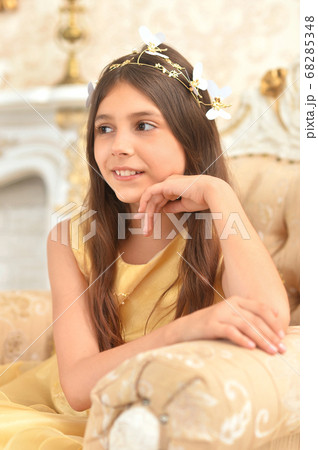 Portrait of girl in yellow dress posing in armchair 68285348