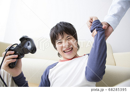 ゲームをする息子と叱る父 68285395