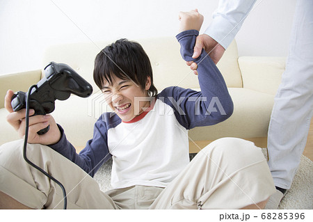 ゲームをする息子と叱る父 68285396