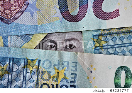 Pile of Euros with eyes peeking out 68285777