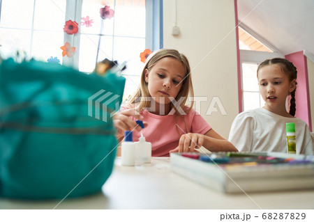 Cute girls communicating during art lesson at school Cute girls communicating during art lesson at school 68287829