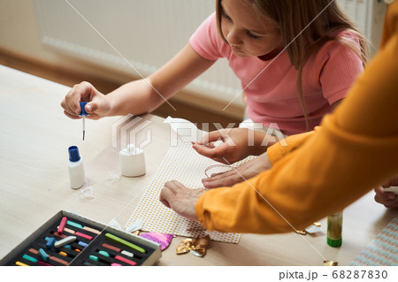 Little girl making handmade application in class room Little girl making handmade application in class room 68287830