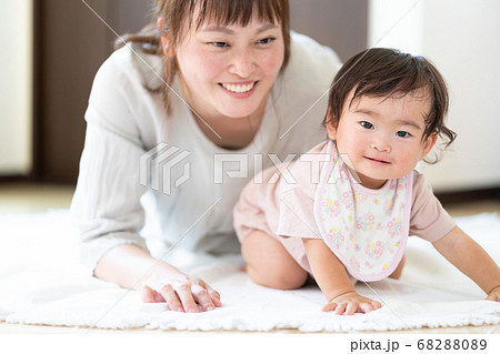 はいはいをする赤ちゃんと寄り添うお母さん はいはいをする赤ちゃんと寄り添うお母さん 68288089