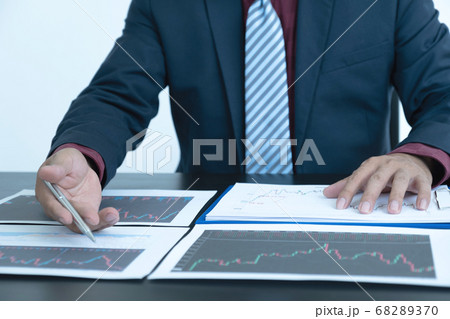 Trader businessmen analyze stock graph and report, set targets for online forex trading Trader businessmen analyze stock graph and report, set targets for online forex trading 68289370