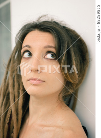 Indoors female portrait of a woman with dreadlocks hairstyle and smoky eyes makeup 68289855