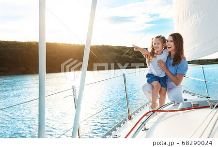 Mother And Daughter Sitting On Yacht Deck Enjoying Sailing Outdoor 68290024
