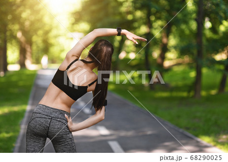 Rear View Of Sporty Woman Warming Up Before Training Outdoors In Park 68290025