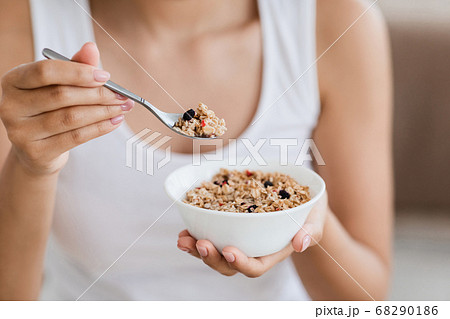Cropped image of woman holding bowl with homemade granola Cropped image of woman holding bowl with homemade granola 68290186