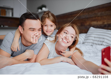 happy smiling family take selfie on bed happy smiling family take selfie on bed 68291108