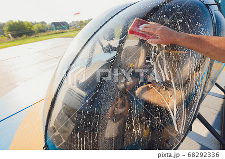 Detail of Helicopter Engineering on a beautiful blue sky,Military Helicopter fighter cockpit. Outdoor wash with sponge and foam. Detail of Helicopter Engineering on a beautiful blue sky,Military Helicopter fighter cockpit. Outdoor wash with sponge and foam. 68292336