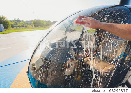 Detail of Helicopter Engineering on a beautiful blue sky,Military Helicopter fighter cockpit. Outdoor wash with sponge and foam. Detail of Helicopter Engineering on a beautiful blue sky,Military Helicopter fighter cockpit. Outdoor wash with sponge and foam. 68292337