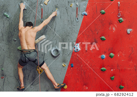 young man having some problems while climbing young man having some problems while climbing 68292412