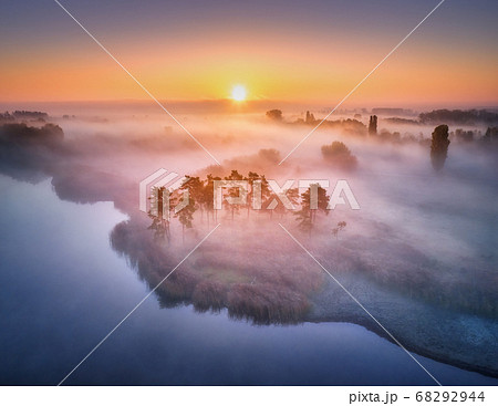 Aerial view of foggy forest at colorful sunrise in 68292944