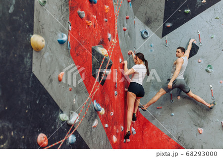 Rear view of woman climber and man instructor giving directions. 68293000
