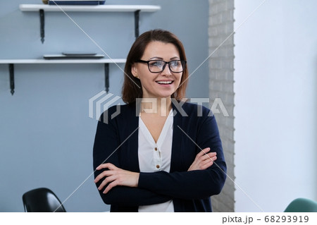 Portrait of positive confident middle aged woman with arms crossed Portrait of positive confident middle aged woman with arms crossed 68293919