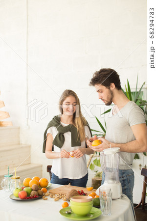 young nice people in stylish clothes are talking while preparing a dish young nice people in stylish clothes are talking while preparing a dish 68294783