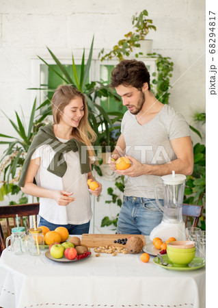 happy attracttive couple preparing a smoothie in the kitchen happy attracttive couple preparing a smoothie in the kitchen 68294817