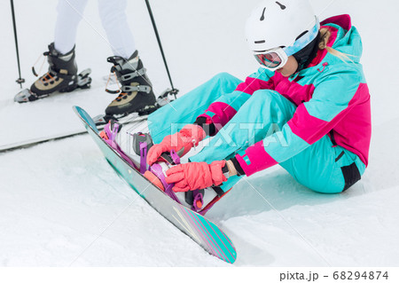 attarctive girl preparing the equipmnet for snowboarding 68294874